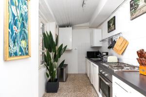 a kitchen with white cabinets and a black counter top at Historic apt in the center of Lucca with Balcony in Lucca