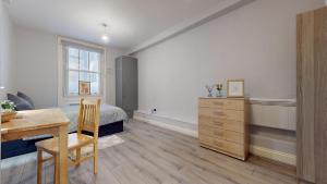 a bedroom with a bed and a desk and a table at Lovely 1 double bed Studio in Marylebone in London