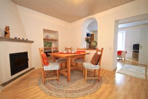 comedor con mesa, sillas y chimenea en Casa Isabella sul Lago Maggiore, en Brissago