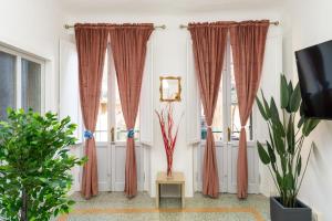 - un salon avec des rideaux rouges et une table dans l'établissement Historic apt in the center of Lucca with Balcony, à Lucques