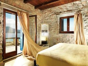 a bedroom with a bed in a room with windows at Villa Icarus, Private Luxury Villa in Kampos Paros