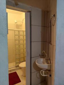 a small bathroom with a toilet and a sink at Cantinho das Olandas in Olinda