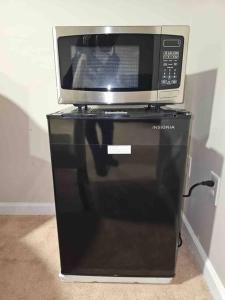 a microwave oven sitting on top of a refrigerator at Lovely furnished apartment in Owings Mills