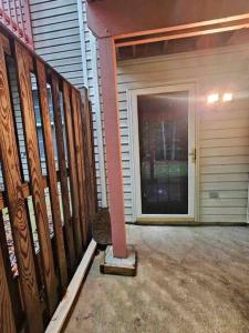 a porch with a door and a pole next to a garage at Lovely furnished apartment in Owings Mills
