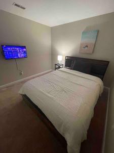 a bedroom with a bed and a tv on the wall at Lovely furnished apartment in Owings Mills