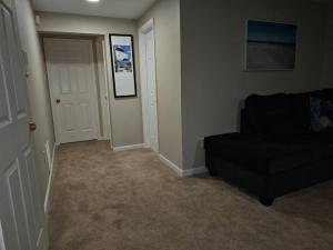 sala de estar con sofá negro y puerta en Lovely furnished apartment, en Owings Mills