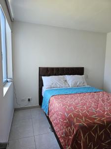 a bedroom with a bed and a window at Apartamento en Ibagué - Varsovia in Ibagué