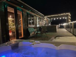 a hot tub on the deck of a house at night at Lush Lodge 