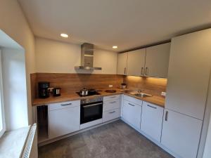 a kitchen with white cabinets and a sink and a stove at Ferienwohnung Ewigkeit - 4-Sterne DTV klassifiziert in Leutkirch im Allgäu