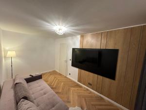 uma sala de estar com um sofá e uma televisão de ecrã plano em Traian Deluxe em Drobeta-Turnu Severin