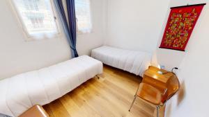 een kamer met 2 witte bedden en een stoel bij Résidence Saint Christophe - 3 Pièces pour 4 Personnes 004 in Menton