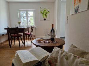 a living room with a table with books and wine glasses at Ferienwohnung Ewigkeit - 4-Sterne DTV klassifiziert in Leutkirch im Allgäu