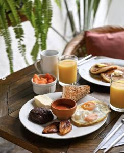 a table with two plates of breakfast foods and orange juice at Cacao Boutique Hotel in Antigua Guatemala