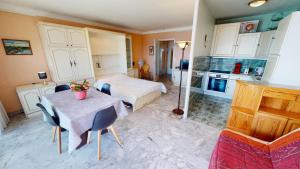 ein Schlafzimmer mit einem Tisch und einem Bett sowie eine Küche in der Unterkunft Résidence Nereides - Studio pour 2 Personnes 184 in Roquebrune-Cap-Martin