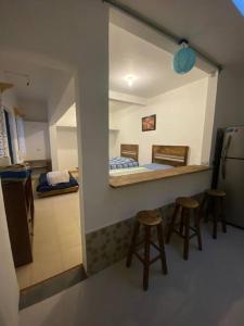 a room with two stools and a kitchen with a counter at Estudio en el centro de Coatepec in Coatepec