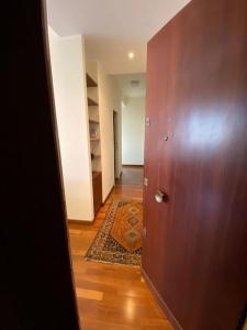 a hallway with a wooden door and a rug at Diamond Apartment in Rome