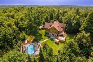 - une vue aérienne sur une grande maison avec une piscine dans l'établissement Chalet Red Deer Spa at Fiddler Lake, à Mille-Isles