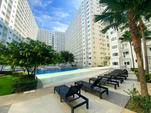 a pool in the middle of a building with benches at Homefort at Shore Residences in Manila