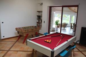 een woonkamer met een pooltafel en een tafel bij gite de la Marzelle in Saint-Sulpice-des-Landes