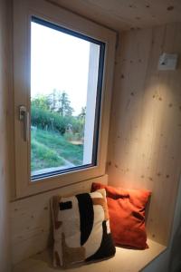 Habitación pequeña con ventana y almohada en Maisonnette de campagne, en Sion