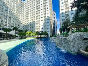 a swimming pool in a city with tall buildings at Homefort at Shore Residences in Manila