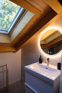 a bathroom with a white sink and a window at Maisonnette de campagne in Sion