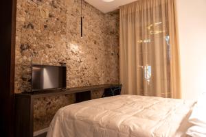 een slaapkamer met een bed en een tv aan de muur bij Dimora Rhea in Salerno