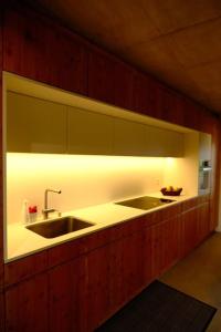 una cocina con fregadero y una luz sobre ella en Maisonnette de campagne, en Sion