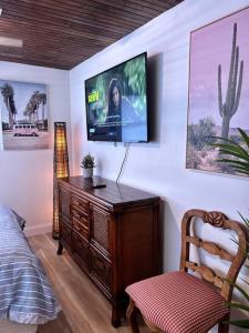 um quarto com uma televisão numa parede com uma cadeira em Piece of Paradise by the Beach 2 em Hypoluxo