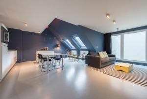 a kitchen and living room with a couch and a table at Smartflats Design - Postiers in Brussels