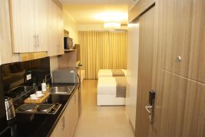 a kitchen with a sink and a room with a bed at Homefort at Shore Residences in Manila