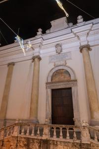 een gebouw met zuilen en een schilderij aan de muur bij Dimora Rhea in Salerno