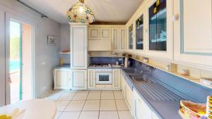 een keuken met witte kasten en blauwe aanrechtbladen bij Résidence Villa Rocca Maria - Maisons & Villas pour 8 Personnes 064 in Menton