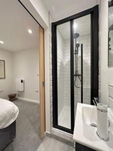 y baño con ducha y lavabo blanco. en Modern apartment in high street location. en Midsomer Norton