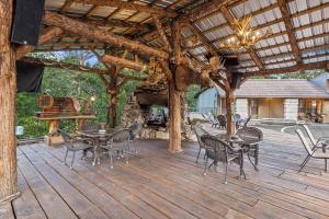 a large wooden deck with tables and chairs on it at Stonegate Lodge King Bed, WIFI, 50in Roku TV, Salt Water Pool Room #103 in Eureka Springs