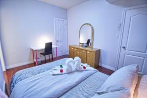 een slaapkamer met een bed met handdoeken en een spiegel bij Private Bathroom and a Free Parking in Vaughan