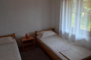 a small bedroom with two beds and a window at Kuca Rancic in Pirot