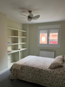 a bedroom with a bed and a ceiling fan at ApartaSoles in Valladolid