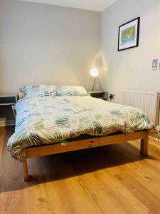 a bed in a bedroom with a wooden floor at Modern Edinburgh Apartment 2 bedrooms & two bathrooms in Edinburgh