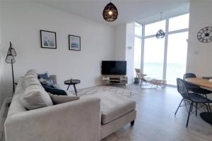 a living room with a couch and a table at Sound of the Sea - Ilfracombe in Ilfracombe