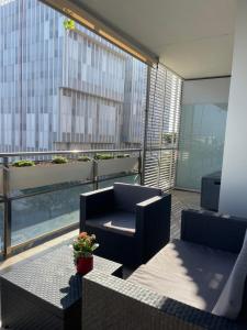 a balcony with a couch and a chair on a building at Diagonal Mar in Barcelona