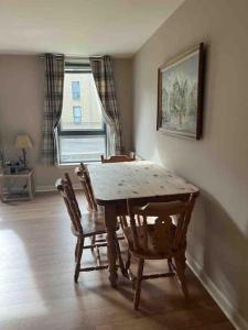 a dining room with a table and chairs and a window at Modern Edinburgh Apartment 2 bedrooms & two bathrooms in Edinburgh