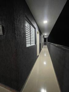 a hallway with a long corridor with a window at POUSADA BRISA MAR in Ubatuba