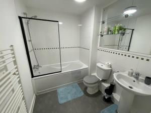 a bathroom with a shower toilet and a sink at Balcony Apartment - Views Of Etihad Stadium - Near CoOp Live Arena in Manchester