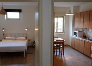 a bedroom with a bed and a table and a kitchen at Home Alle Cascate in Corleone