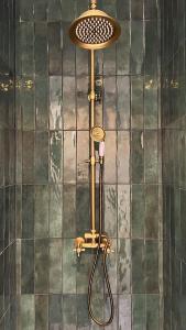 a shower in the corner of a tiled wall at The Brick House - Appartement Renoir in La Roche-Guyon