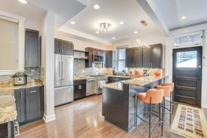 a kitchen with black cabinets and orange bar stools at Spacious Chicago Home with Deck about 3 Mi to Downtown! in Chicago