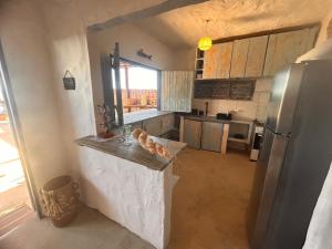 a kitchen with a counter and a refrigerator at Casa Aconchego da Redonda in Icapuí