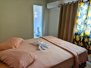 Una cama con una toalla en un dormitorio en Pousada Mirante do Sol en Piúma