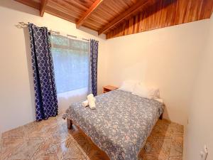 um quarto com uma cama e uma janela em Edén Guest House em Monteverde